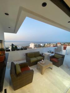 a living room with couches and a view of the ocean at Bouchareb résidences in Quşaybat al Madyūnī