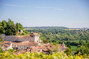 a group of buildings on a hill with trees at Barque Fleurie Maison Retro avec Jardin et Parking au coeur d'Aubeterre-sur-Dronne in Aubeterre-sur-Dronne