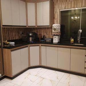 a kitchen with white cabinets and a counter top at Casa familiar in Piên +7 photos