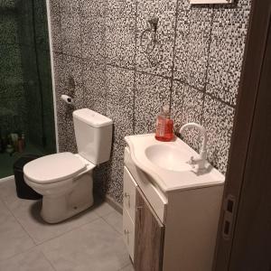 a bathroom with a toilet and a sink at Casa familiar in Piên