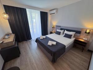 Un pat sau paturi într-o cameră la Hotel Artemis +28 fotografii
