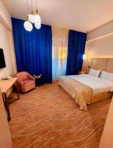 a bedroom with a bed and a chair and blue curtains at Sierra in Piteşti +52 photos