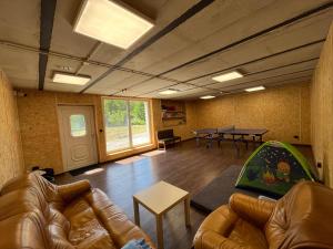 a living room with a couch and a table at Tawerna Pod Kotwicą pokoje i domy wakacyjne in Kadłub Wolny