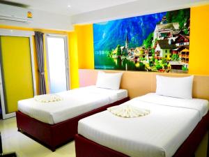 two beds in a room with a painting on the wall at Blue Orchids Hotel in Hat Yai +25 photos