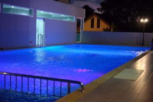a large swimming pool at night with blue lighting at Blue Orchids Hotel in Hat Yai