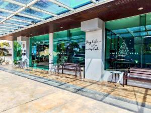 a store front with benches and a christmas tree in the window at Blue Orchids Hotel in Hat Yai