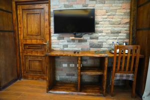 a wooden desk with a television on a brick wall at Noora Resort Bishoftu in Debre Zeyit