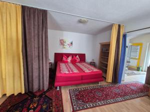a living room with a red bed in a room at Bed & Breakfast Simone in Imst