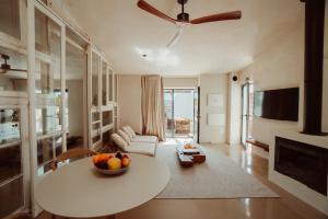 a living room with a table and a ceiling fan at Suites Daldeia - Suite 1 in Azueira