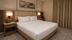 a large white bed in a hotel room at NARS Plus Serviced Apartments - Al Nuzha in Jeddah