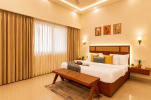 a hotel room with a bed and a table at Manovan Resort by Eastlynn Experiences, Jim Corbett in Belparāo