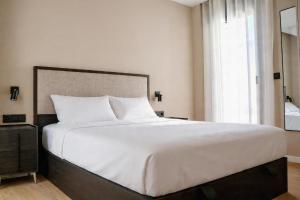 a large white bed in a bedroom with a window at TeneaHome - Escuelas Pías in Yecla