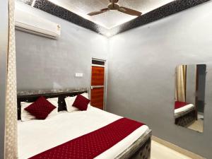 a bedroom with a bed and a ceiling fan at Hotel O Suryavanshi Palace in Ayodhya +19 photos