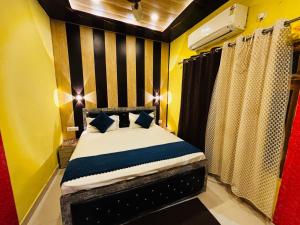 a small bedroom with a bed with blue pillows at Hotel O Suryavanshi Palace in Ayodhya