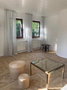 a living room with a glass table and two stools at Refugium - central, quiet apartment with terrace in Frankenberg