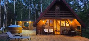 a log cabin with a deck and a hot tub at Wypoczynek "POD BRZÓSTKAMI" in Nagłowice