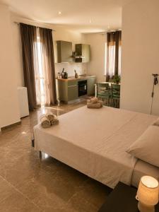 a bedroom with a large bed and a kitchen at I Due Moli 2'0 Vibo Marina in Vibo Valentia Marina