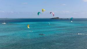 a group of people flying kites in the ocean at EcoDream Lodge in Port Mathurin