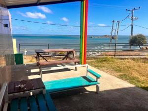a picnic table and a bench in front of the ocean at EcoDream Lodge in Port Mathurin