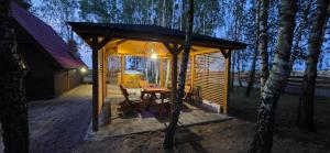 a cabin with a table and chairs in the woods at Wypoczynek "POD BRZÓSTKAMI" in Nagłowice