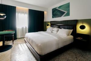 a bedroom with a large bed and a table at Hotel Lepic in Abidjan +24 photos