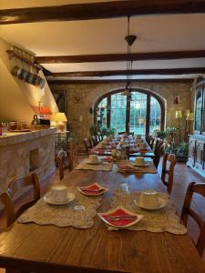 a large dining room with a long wooden table at La Ferme Terre Bio Provence in Lapalud