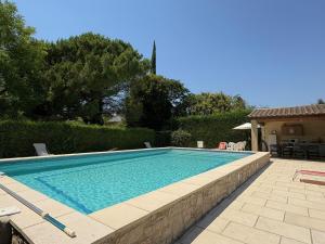 a swimming pool in a yard with a house at La Ferme Terre Bio Provence in Lapalud