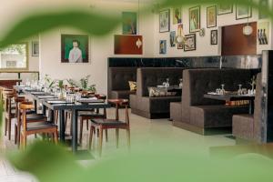 a dining room with tables and chairs and couches at Hotel Lepic in Abidjan