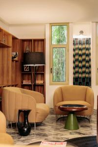 a living room with two chairs and a table at Hotel Lepic in Abidjan