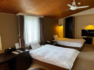 a hotel room with two beds and a ceiling fan at Hotel Karuizawa Elegance in Karuizawa +63 photos