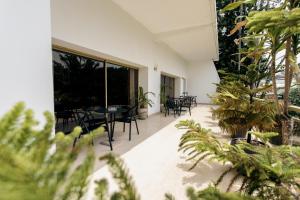 a patio with tables and chairs and plants at Hotel Lepic in Abidjan