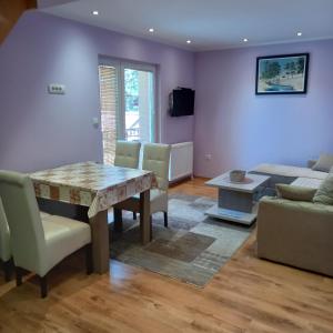 a living room with a table and chairs and a couch at Apartmani Aleksijević Zlatibor in Zlatibor