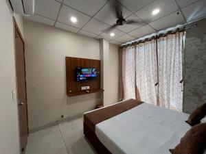 a bedroom with a bed and a tv on the wall at Hotel Dreamland in Hisār
