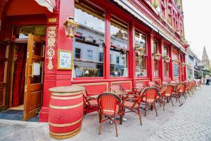 a row of tables and chairs outside of a red building at The Goat in Boots in London