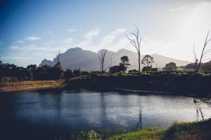 un bacino d’acqua con montagne sullo sfondo di Station House Simondium a Simondium