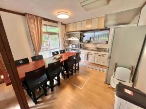 a kitchen with a dining room table and chairs at Cruise garden in Kanō