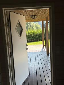 an open door to a porch with a wooden deck at Family Cabins in Fjæra