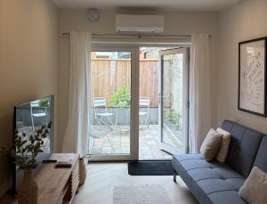 a living room with a blue couch and a sliding glass door at Herberg de Smederij in Kampen