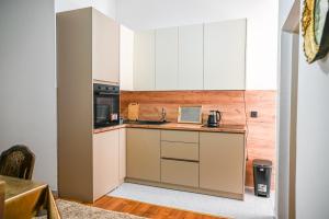 a small kitchen with white cabinets and a sink at Guesthouse Elsa in Ulcinj