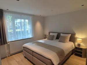 una camera da letto con un grande letto e una finestra di Hof van Bergen a Bergen