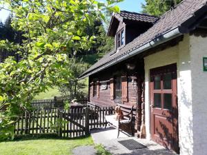 a dog sitting on a bench outside of a house at UMUNDUM Hütte in Katsch Oberdorf