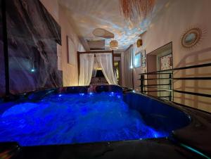 a blue tub in a room with a ceiling at Loveroom Romantique avec Spa et Secret Room - A proximité des Lacs - La Mure in La Mure