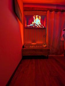 a room with a television with a fire in it at Loveroom Romantique avec Spa et Secret Room - A proximité des Lacs - La Mure in La Mure