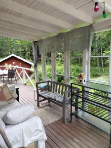 a screened in porch with a bench and a table at Cottage / Mökki, unique summer cottage in Vihti