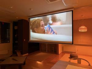 a large flat screen television with a movie on it at Grand Opening SORA Yunokawa Penthouse in Hakodate