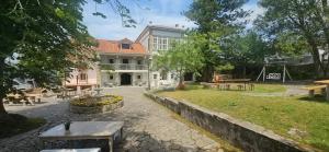 a building with a park with benches and tables at Planazo House in Arnuero