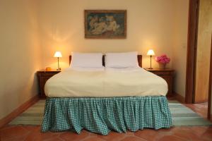 Bett in einem Zimmer mit 2 Tischen und 2 Lampen in der Unterkunft Tenuta Guazzaura in Serralunga di Crea