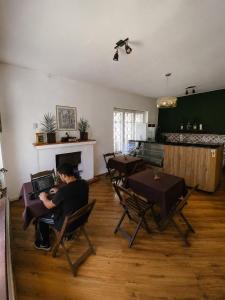 a man sitting in a chair with a laptop in a room at Garibaldi Hostel & Pub in Curitiba