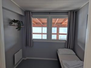 a small room with a window and a couch at Egenes Camping in Flekkefjord