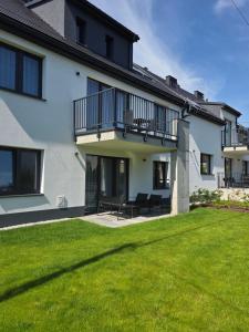 a house with a green lawn in front of it at Calma - apartamenty z ogrodem blisko Energylandii in Zator